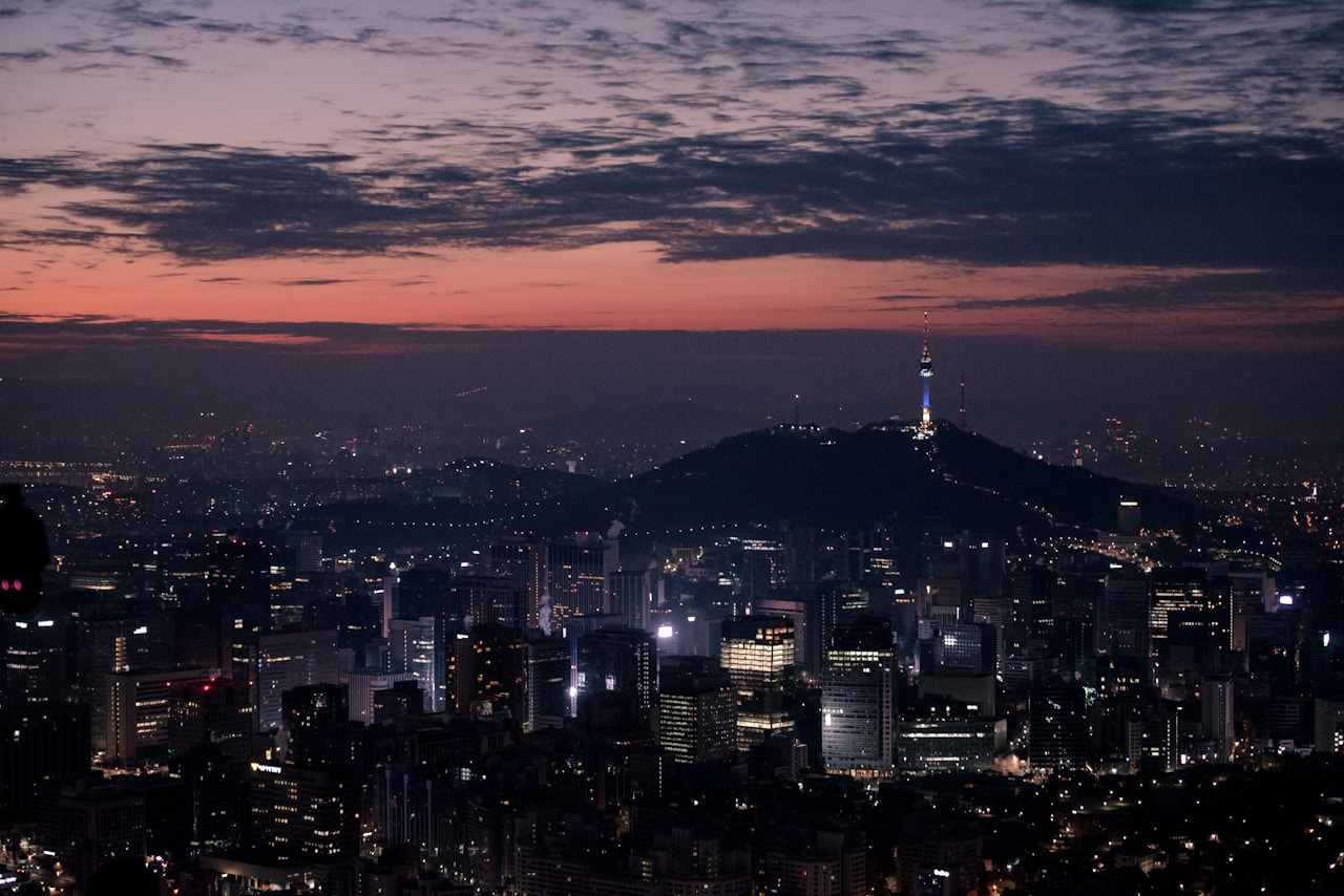 Top Korean Entertainment Agencies: The 2026 Producer's Guide 2 Seoul city skyline at dusk with N Seoul Tower illuminated above the dense urban landscape