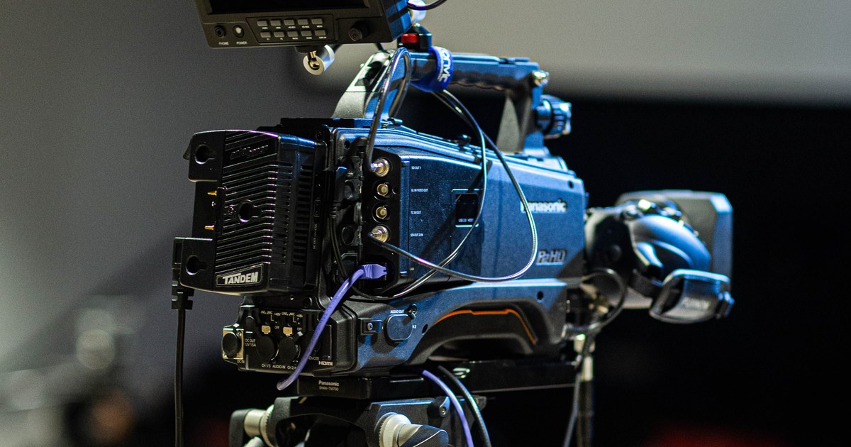Professional broadcast video camera on a tripod in a studio, representing documentary production equipment