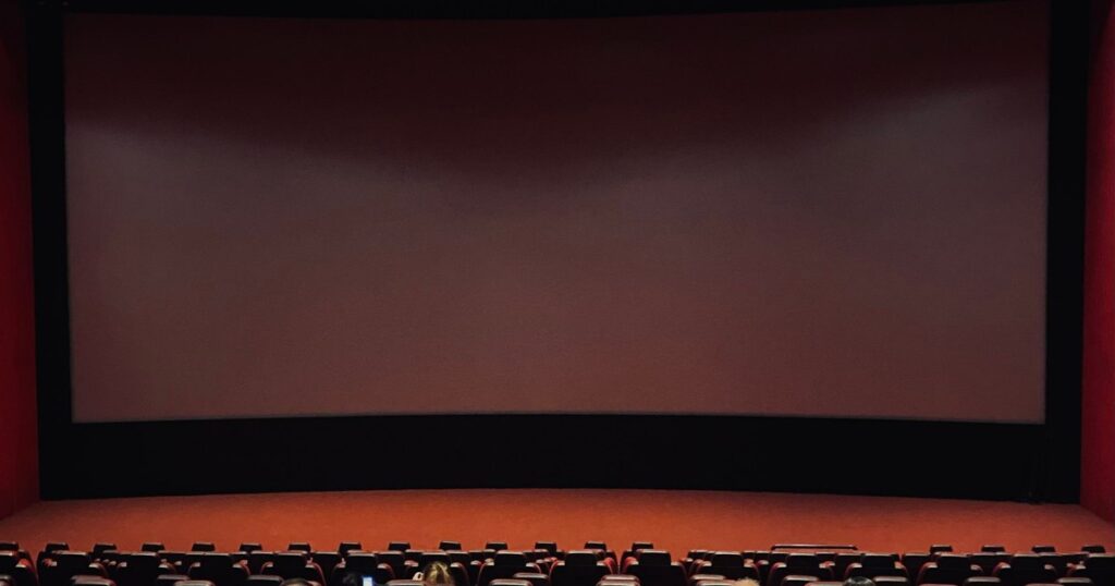 Film Licensing Deals Explained 6 Empty cinema screen and seating, representing theatrical and Pay-1 licensing windows in a film distribution deal