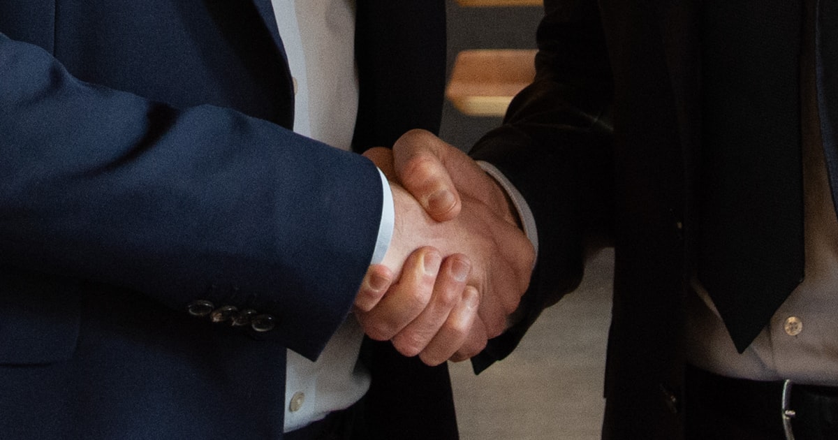 Business professionals shaking hands representing isekai anime co-production and international distribution deal structures