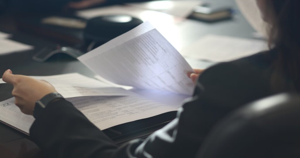 Business professional analyzing documents for isekai anime IP deal sourcing and acquisition scouting