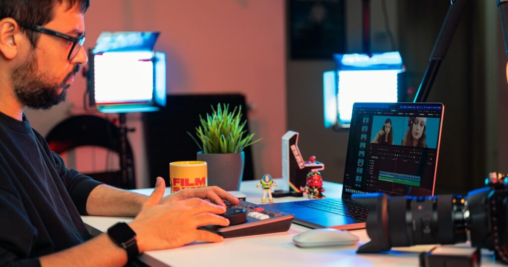 Filmmaker editing video on laptop representing streaming platform slate strategy for isekai anime acquisitions