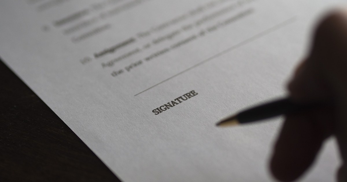 Television Rights Management: A Complete Guide for Distributors and Rights Holders 2 Close-up of a businessman signing a formal licensing contract with a pen, symbolizing television rights management agreements.
